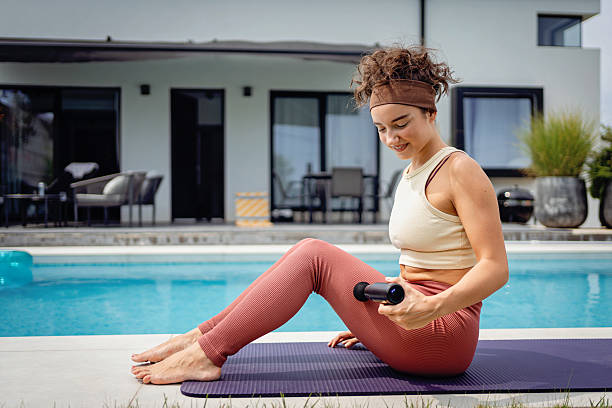 istock Woman practicing yoga with weights beside a pool on a sunny day 2233908118