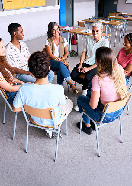 istock High school students and teacher talking in a circle in classroom 2233915093
