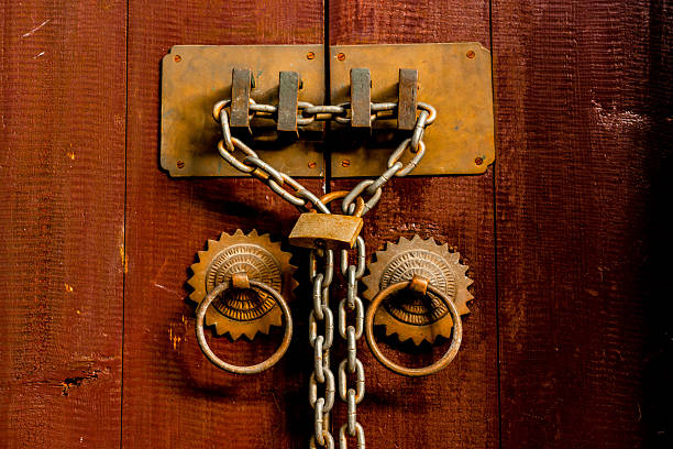 Rusty padlock and chain securing an old wooden door in yuen long, hong kong