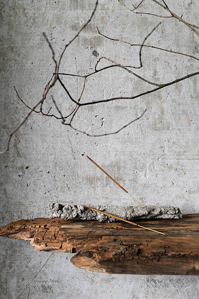 istock Minimalist still life in wabi-sabi style. Burning incense stick on a rustic holder, placed against a textured concrete wall. 2233920226
