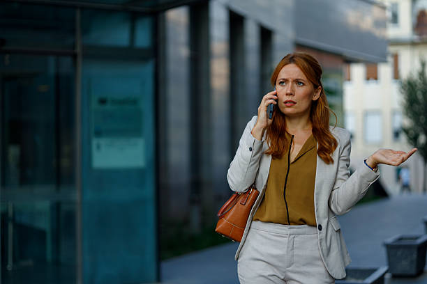 istock Frustrated businesswoman talking on smartphone, gesturing expressively while walking along a bustling city street, facing communication challenges 2233920399