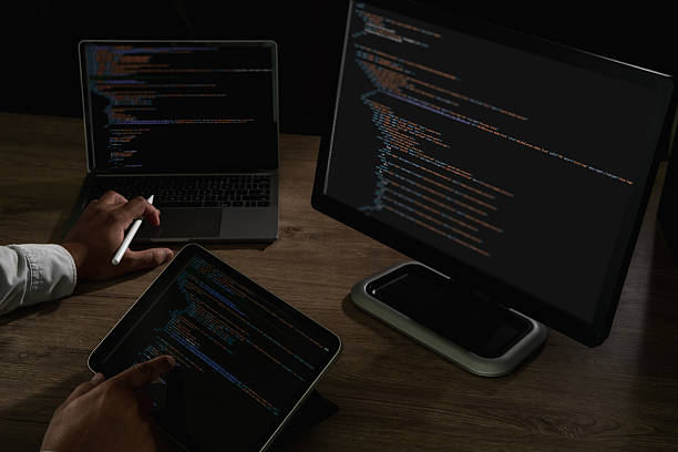 istock Programmer pointing at laptop screen with visible lines of code and tablet beside, concept of coding, software development, IT, cybersecurity, and digital technology innovation. 2233923378