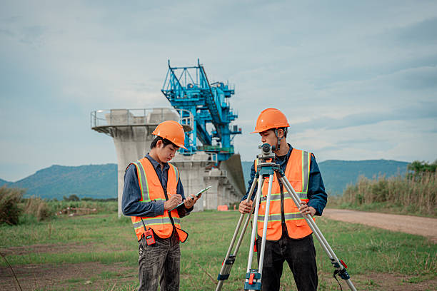 istock Engineers are conducting land surveying construction site using theodolite instrument mounted tripod measure land levels and distances project planning in the civil engineering and industrial development sector. 2233929618