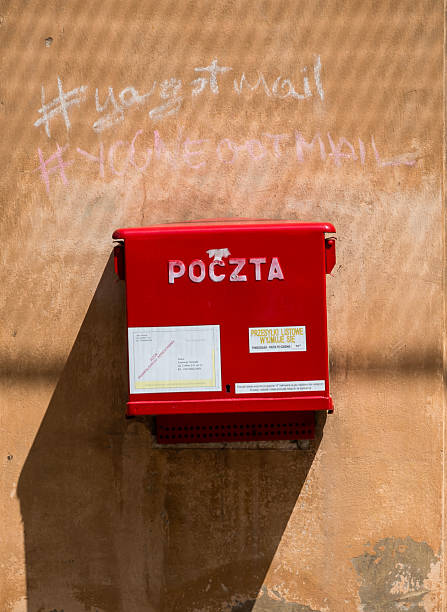 Warsaw, Poland - June 25, 2015 - Red outdoor polish post box on textured wall with chalk graffiti.
