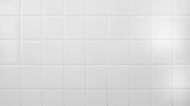 istock white tiles wall in the office. White tiled wall for bedroom, kitchen, bathroom and interior design. White tiled wall in clean and symmetrical textured background view with grid texture background. 2233930083