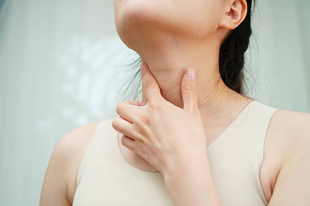 istock Asian woman touching her neck and throat for thyroid gland problem. 2233930843