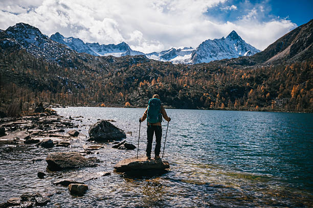 Backpacking woman walking in the beautiful sunset lake