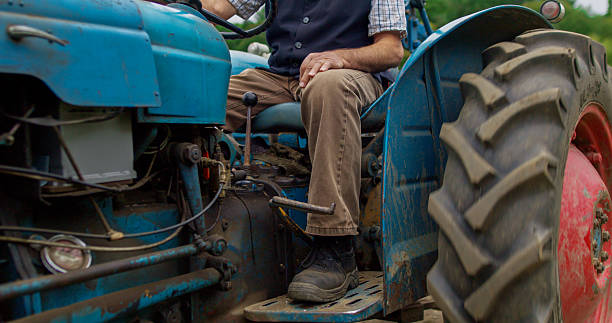 istock Low Angle Shot of Senior Farmer Sitting on a Tractor 2233932444