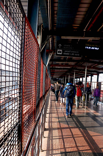 istock Passengers Walking on Railway Foot Overbridge with Safety Grill 2233939421
