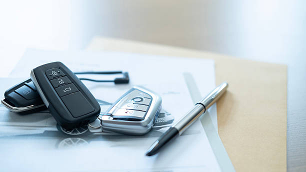 istock Remote car keys and pen placed on a document representing contract signing automobile purchase and ownership transfer 2233944674
