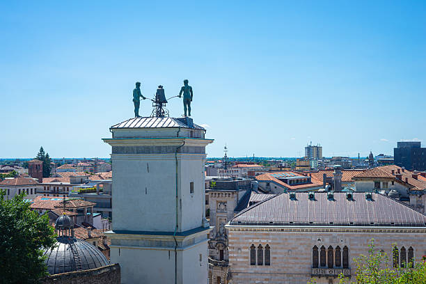Udine, Italy - August 5, 2025: Clock tower of Udine (Italian: Torre dell'Orologio) with two carved figures striking the hours on a clock standing between them.