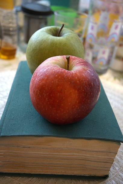 istock Red and green apples on thick green book 2233951105