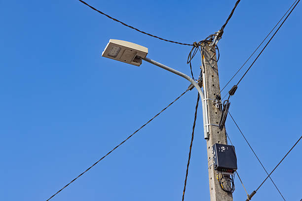 istock A power pole and street light against a clear blue sky. 2233952422