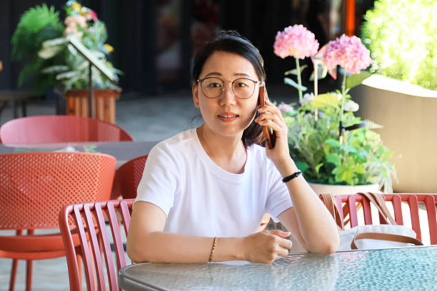 istock An Asian woman using a mobile phone in a cafe 2233953367