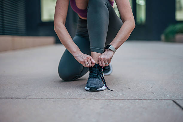 istock Female athlete tying shoelaces before urban workout 2233961074