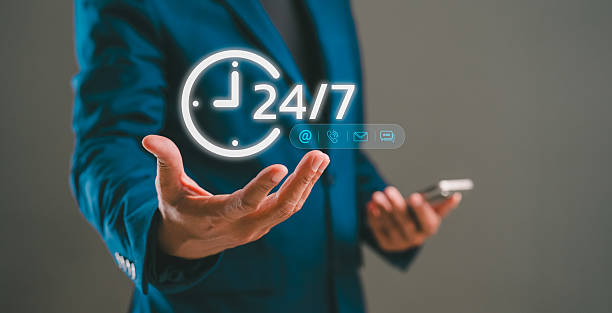 istock A professional man in a suit displays a digital clock symbolizing 24/7 availability while holding a smartphone, indicating readiness and connectivity. 2233963799