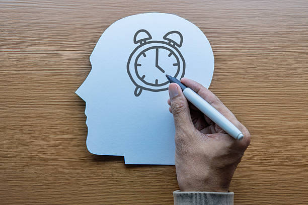istock A head-shaped cutout with a hand drawing an alarm clock. 2233964270