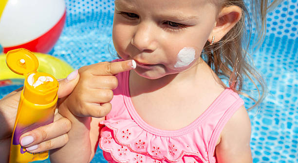 istock Applying Sunscreen to Child Arm by the Pool 2233964481
