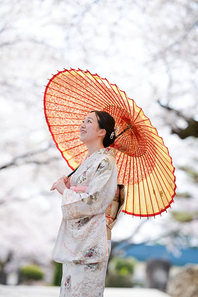 istock A woman wearing a kimono stands under an umbrella 2233968713