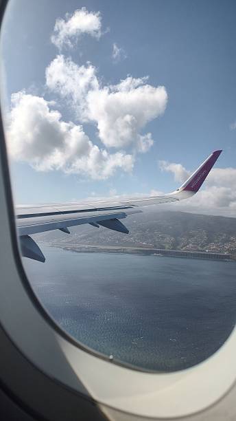 istock View of Madeira island from airplane window with clouds and wing 2233969002