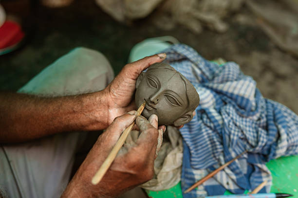 istock Old mam Durga murti face making with clay closeup image 2233972338
