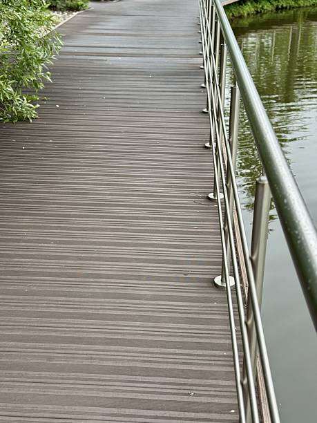 istock A Stylish Walkway Featuring Elegant Railings Alongside a Peaceful and Tranquil Water Body. A modern walkway designed with stainless steel railings gracefully lines a calm and serene body of water. 2233972624