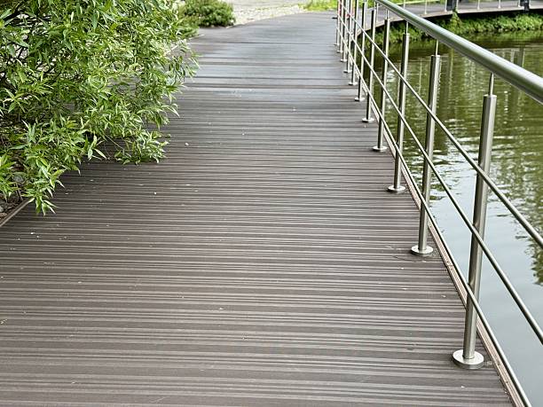 istock A Stylish Walkway Featuring Elegant Railings Alongside a Peaceful and Tranquil Water Body. A modern walkway designed with stainless steel railings gracefully lines a calm and serene body of water. 2233974064