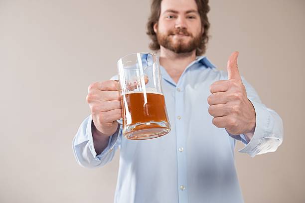 istock Man holding beer and giving thumbs up 2233977346