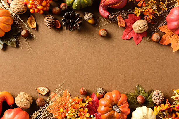 istock Fall border composition on brown background with pumpkins, pinecones, nuts, wheat stalks, berries and colorful leaves 2233983018