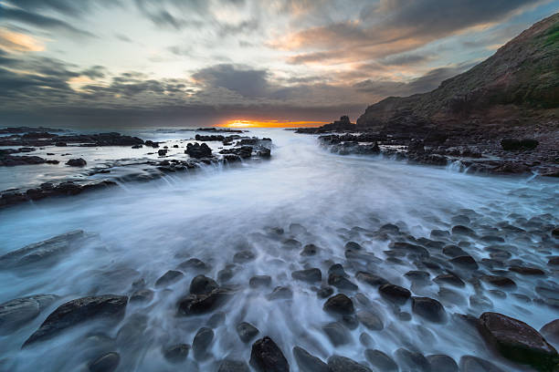 istock Rocky Coastal Landscape at Sunset with Long Exposure Water 2233987178
