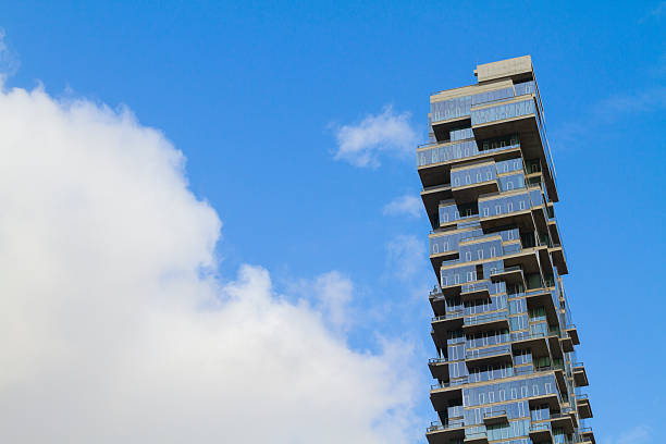 Modern multi-storey building in a low angle view at Miami, Florida. Hotel  Apartment building exterior with balconies on both corners view from below under the sky.