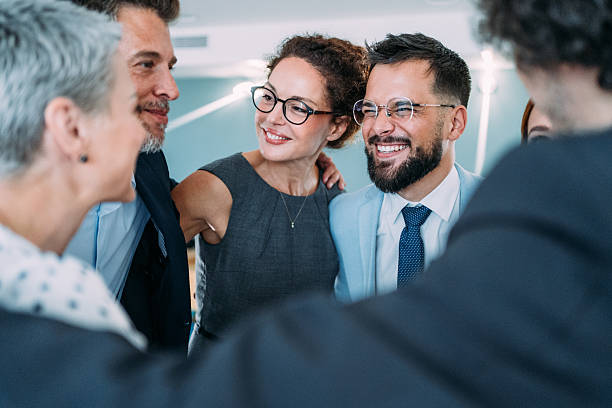 istock Excited coworkers embracing each other during a celebration in the office. 2233992401