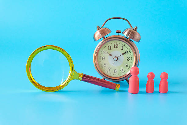 istock Alarm clock and Magnifying glass on background. 2233992676