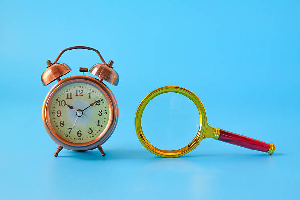 istock Alarm clock and Magnifying glass on background. 2233992682