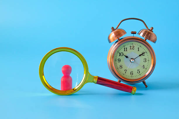 istock Alarm clock and Magnifying glass on background. 2233992685