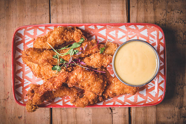 istock Crispy Breaded Chicken Strips on Patterned Plate With Creamy Dipping Sauce 2233992981