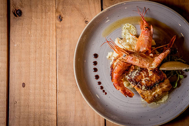 istock Gourmet Seafood Dish Featuring Grilled Shrimp and Fish on Rustic Table 2233993380