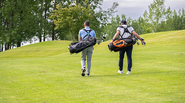 istock Two Male Golfers Walking Along Golf Fairway 2233996034