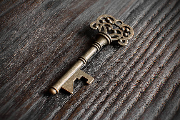 istock Brass key with ornate design placed on wood 2233997832