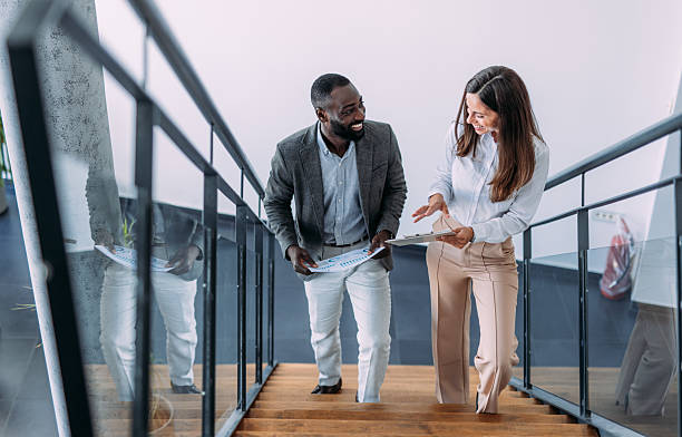 istock Business colleagues talking on stairs in the office. 2233997859