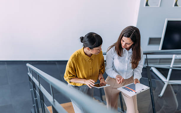 istock Business colleagues talking on stairs in the office. 2233997866