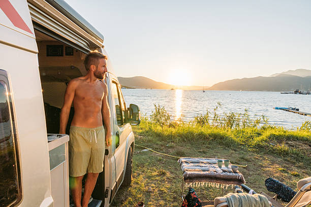 istock Man Enjoying Sunset by Camper Van Lake 2234001749