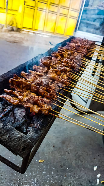 istock chicken satay with charcoal ingredient on red fire grilling by people. 2234005177