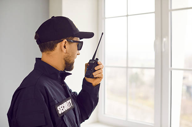 istock Male security guard is talking on his radio while standing by window inside house 2234012714