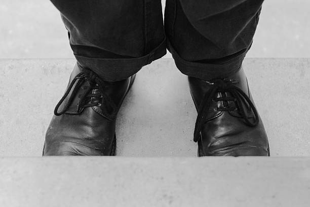 black shoes and black pants on a gray concrete staircase