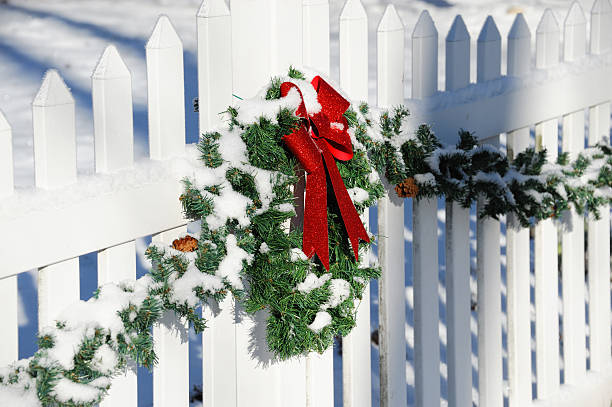 istock Christmas wreath hanging on white fence 2234013134