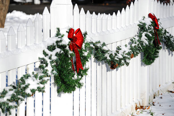 istock Christmas wreath hanging on white fence 2234013152