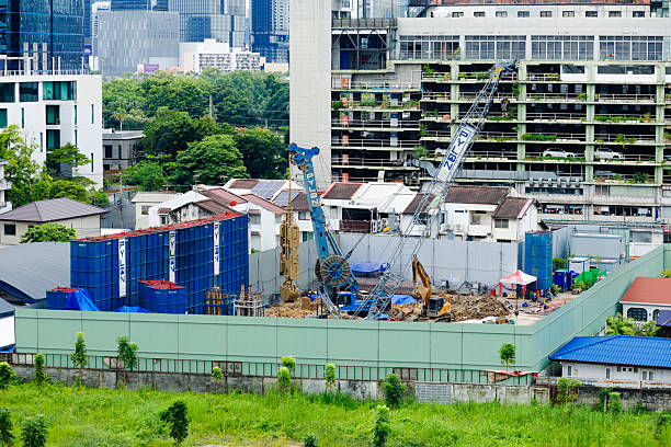 High angle view of construction site in Bangkok downtown. Yard is in back of skyscrapers in area of junction Asok - Sukhumvit Road.. Construction works for new building in residential area has just started