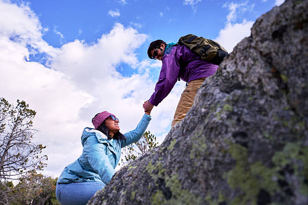 istock Hikers helping each other in the mountains. 2234015692