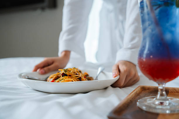 Room service hotel staff carries breakfast tray